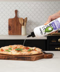 Garlic Infused Avocado Oil Bottle pouring oil on a pizza